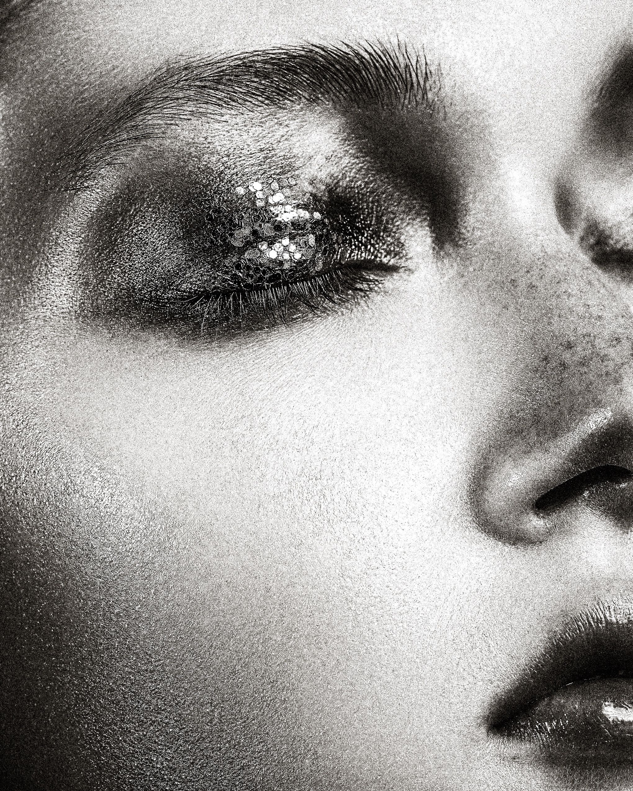 Extreme close-up black and white beauty shots focusing on eyes, nose and lips with soft lighting effects.