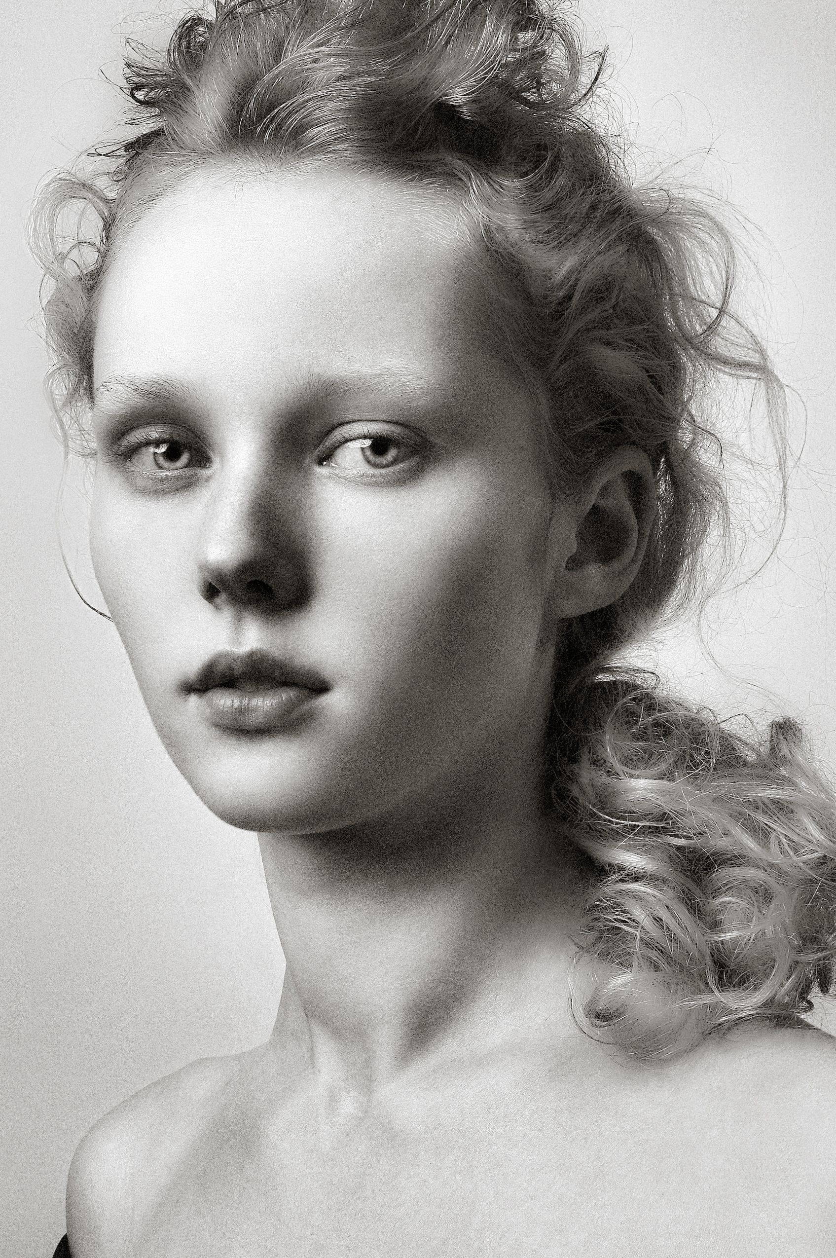 Artistic black and white portrait series showing ethereal expressions and soft lighting against a minimal background.