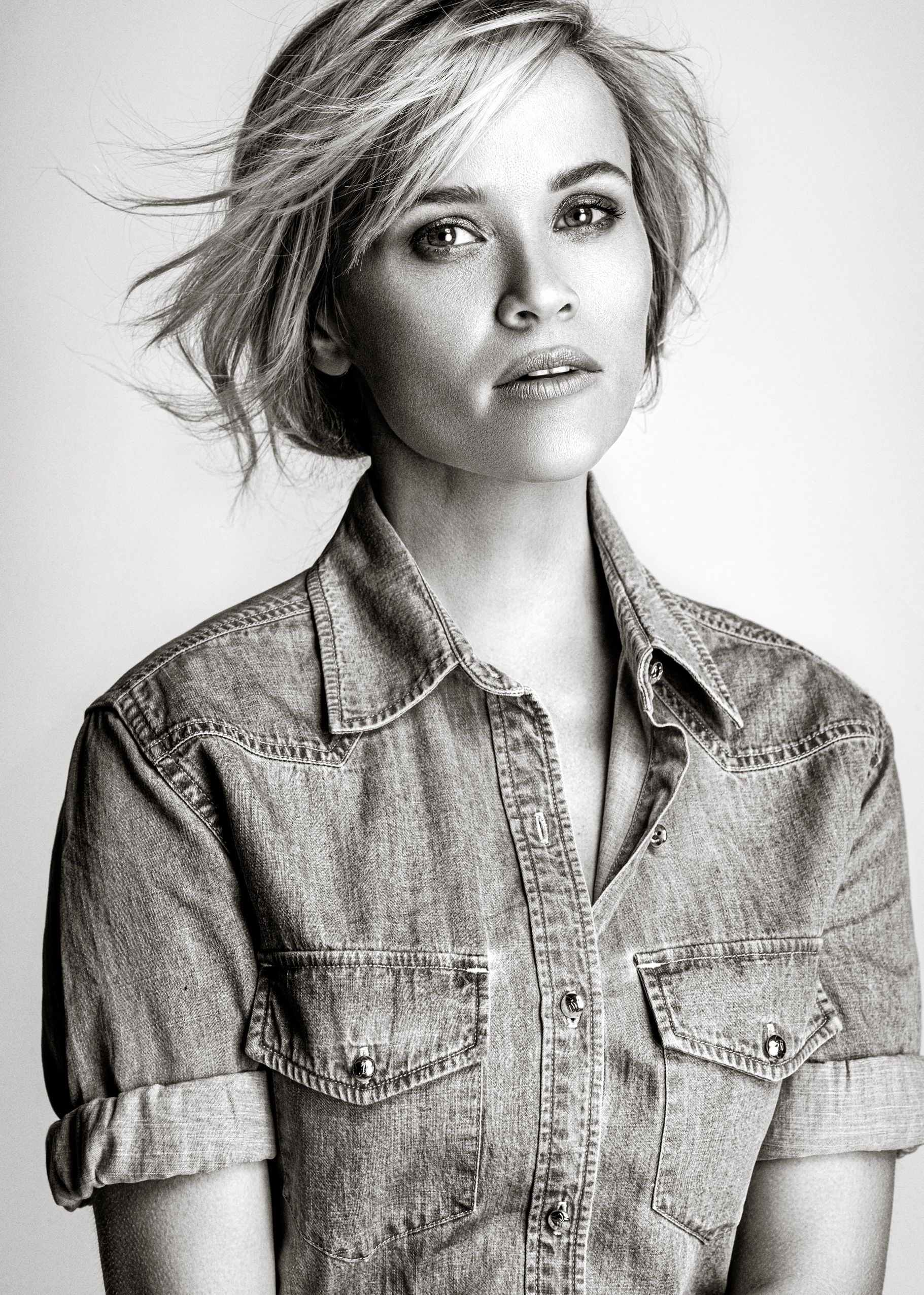 Black and white fashion portrait series showing a model in a casual denim jacket against a white background.