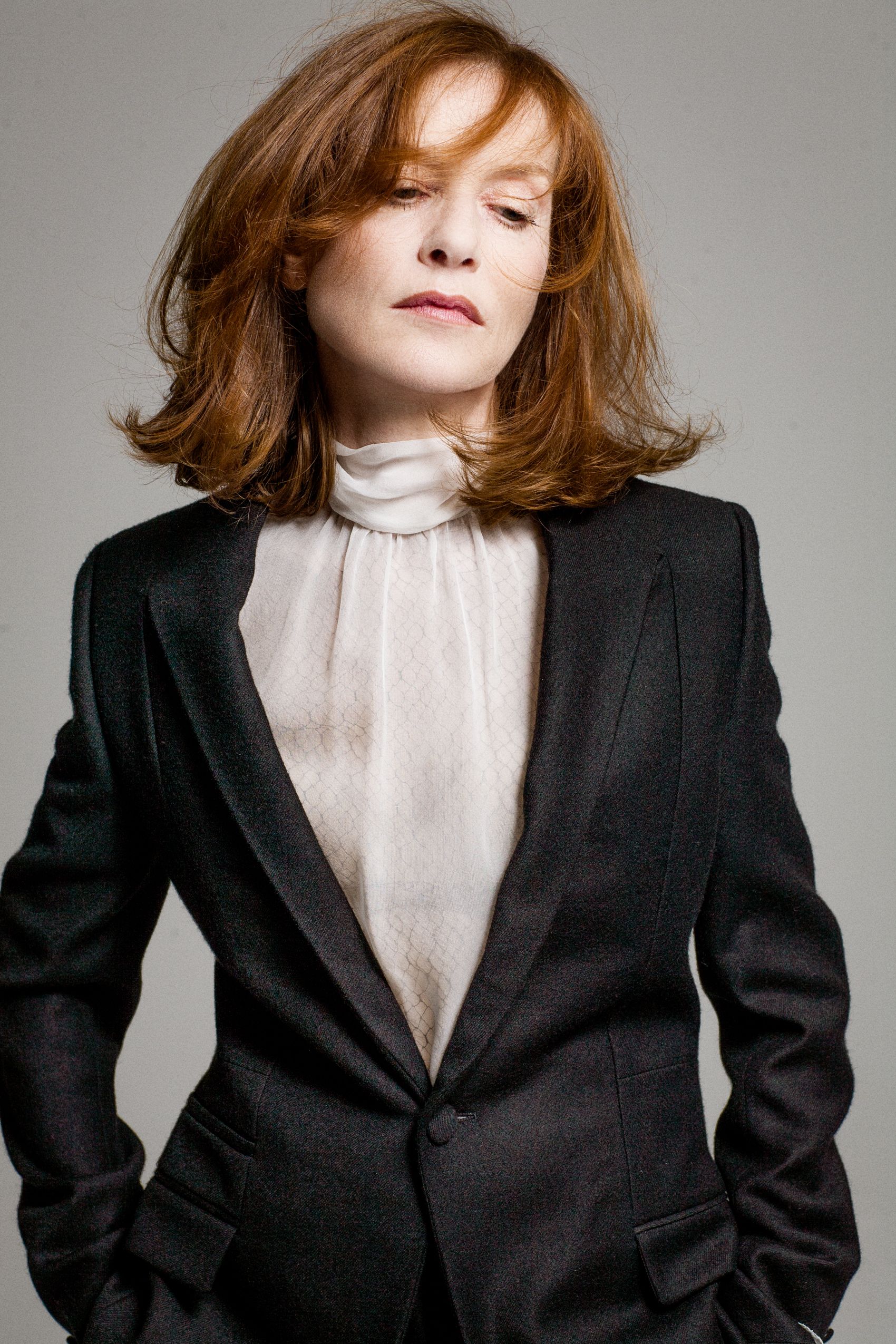 Fashion portrait series showing model in black blazer and white blouse with auburn hair against gray backdrop.