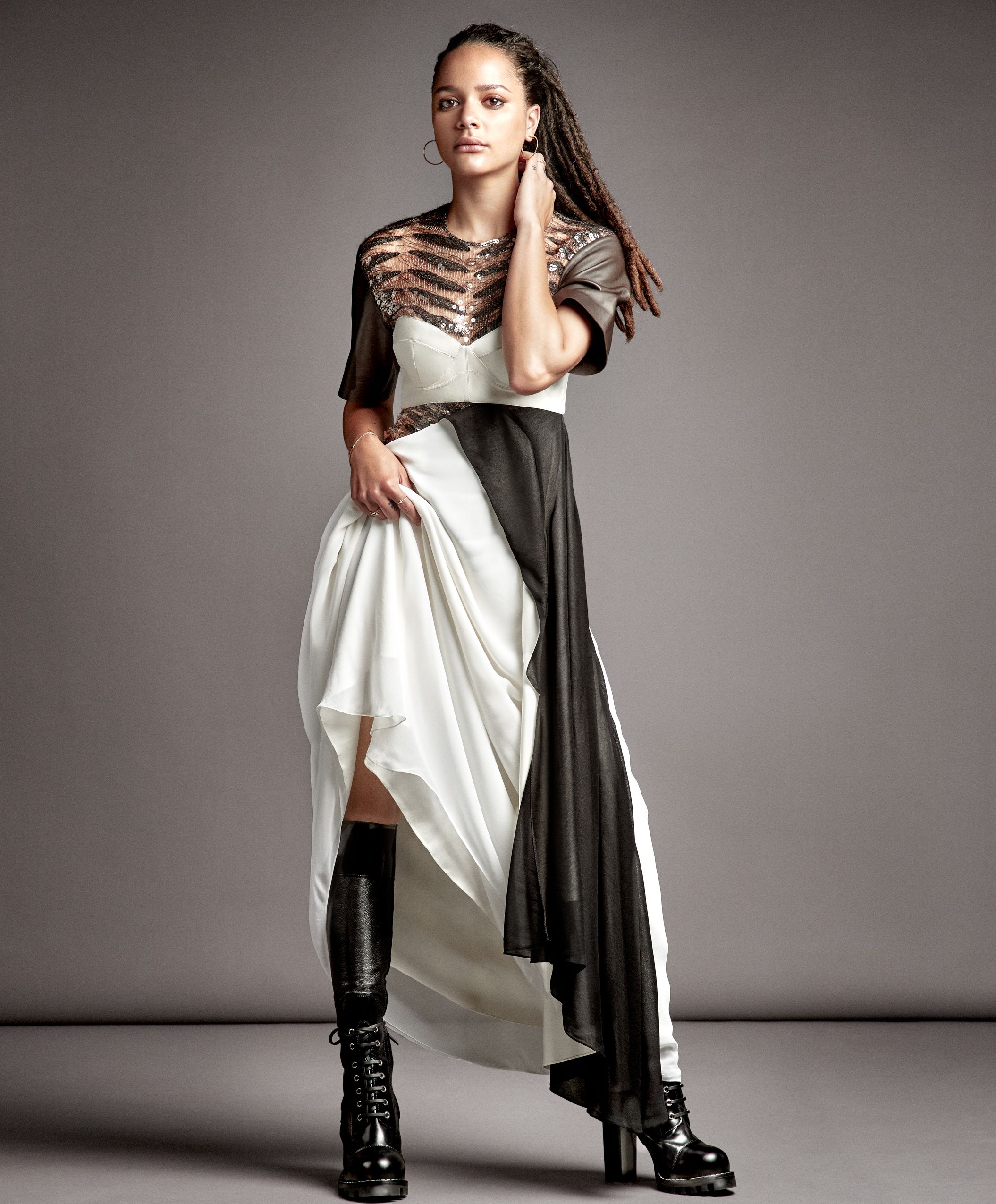 Fashion model poses in white dress and black boots against grey background showing dynamic movement sequence.