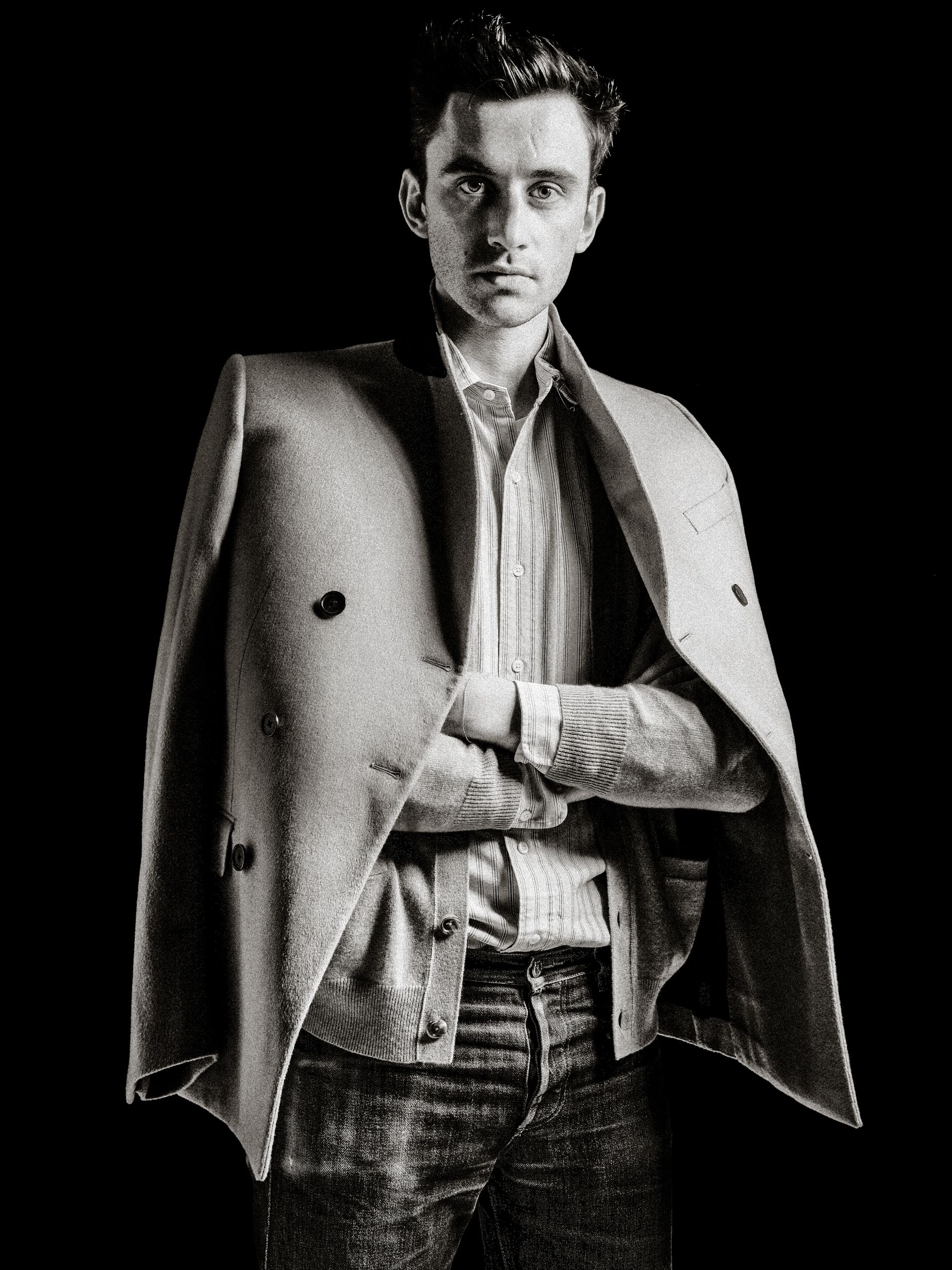 Black and white fashion photo series showing a person wearing a light colored blazer and white shirt against dark background.