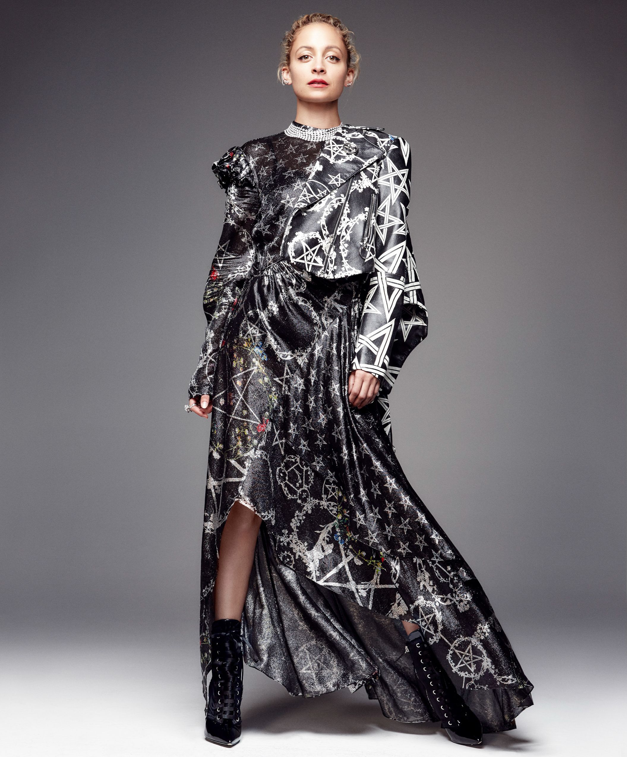 Model wearing flowing black and white floral print gown in artistic studio photoshoot.