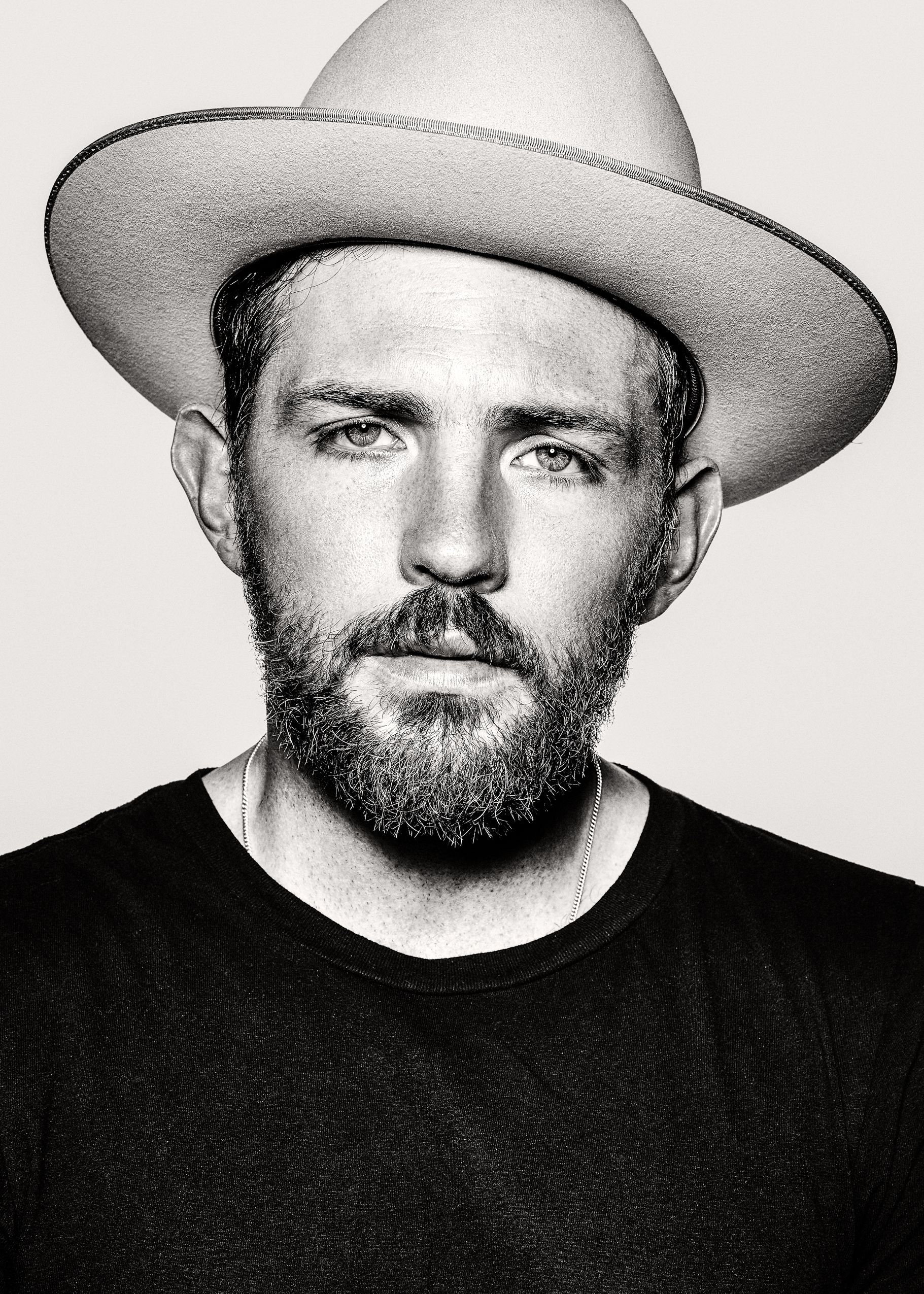Black and white portrait series showing man in cowboy hat and black shirt from different angles.