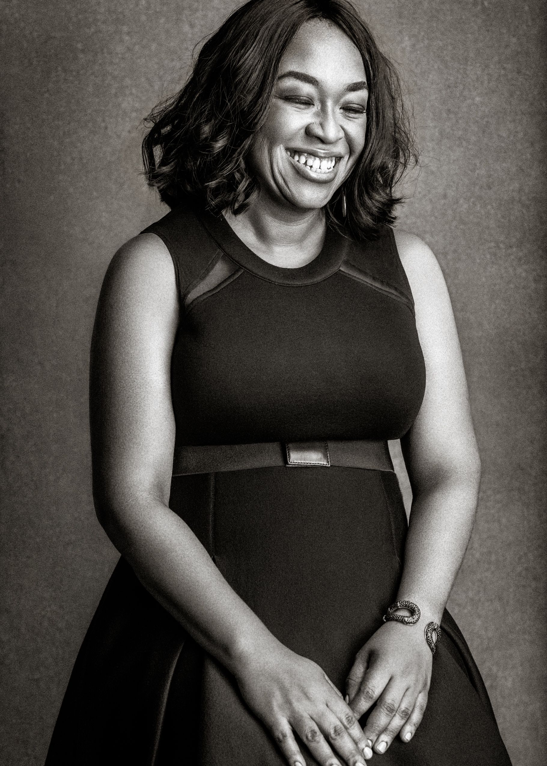 A series of black and white portraits showing a person in a black sleeveless dress expressing joyful emotions.
