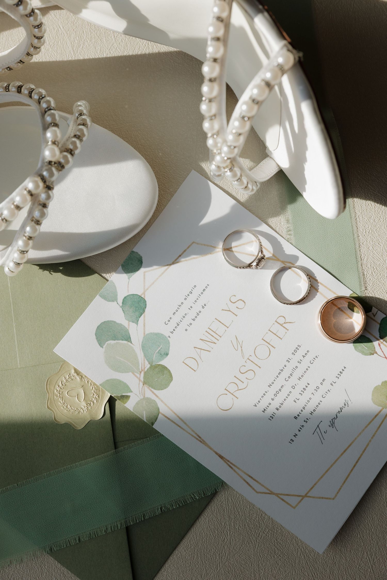 Elegant white and gold wedding invitation cards with eucalyptus leaf details arranged in a sequence.