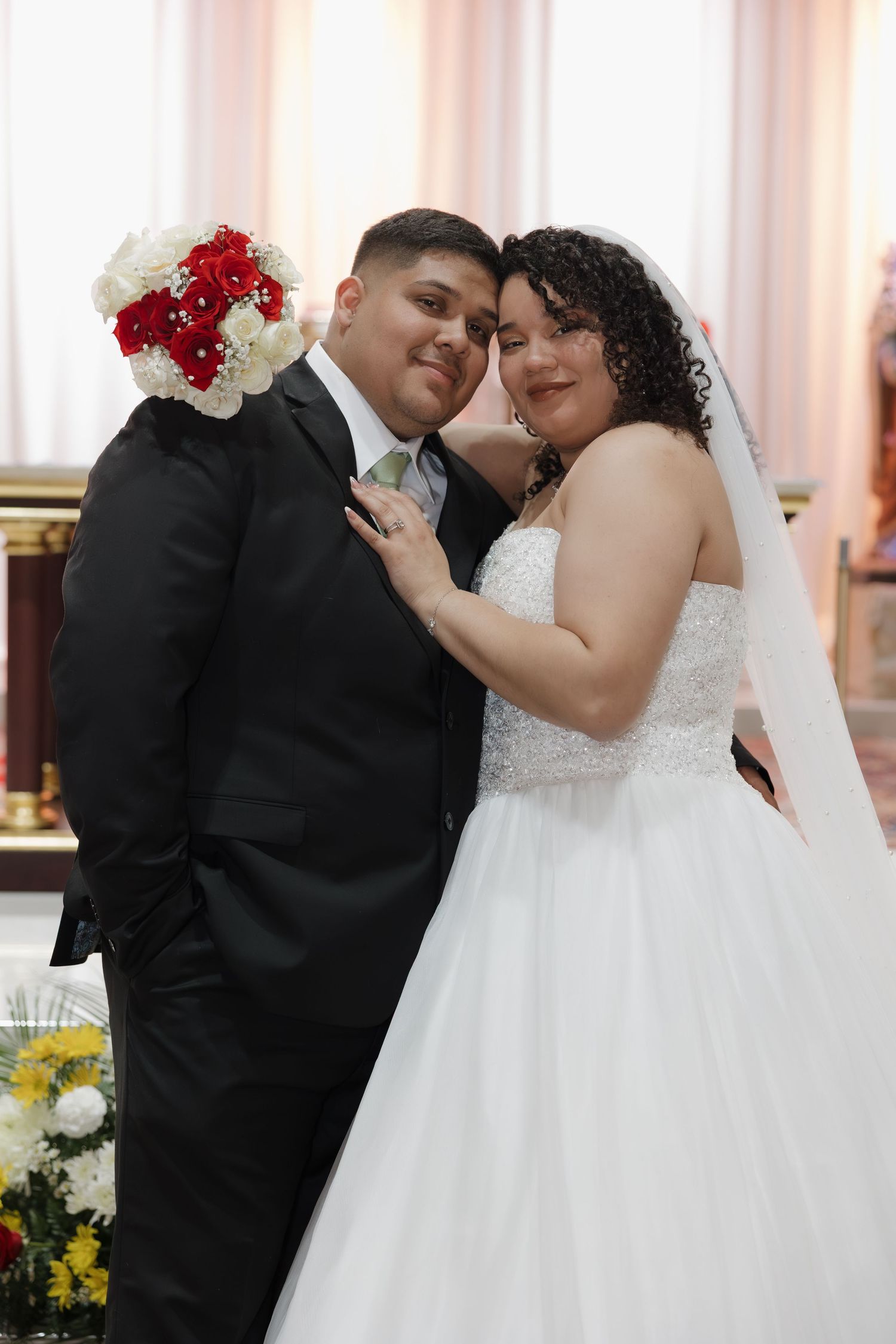 A romantic moment between newlyweds with red and white floral decorations.