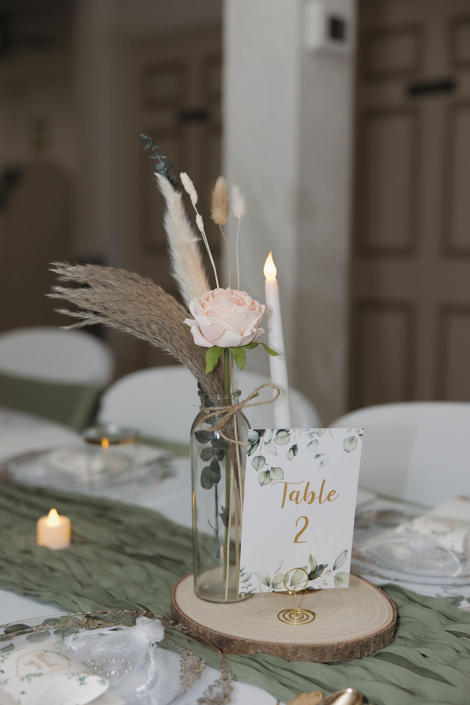 Rustic wedding table settings with wooden slices, candles and floral centerpieces.