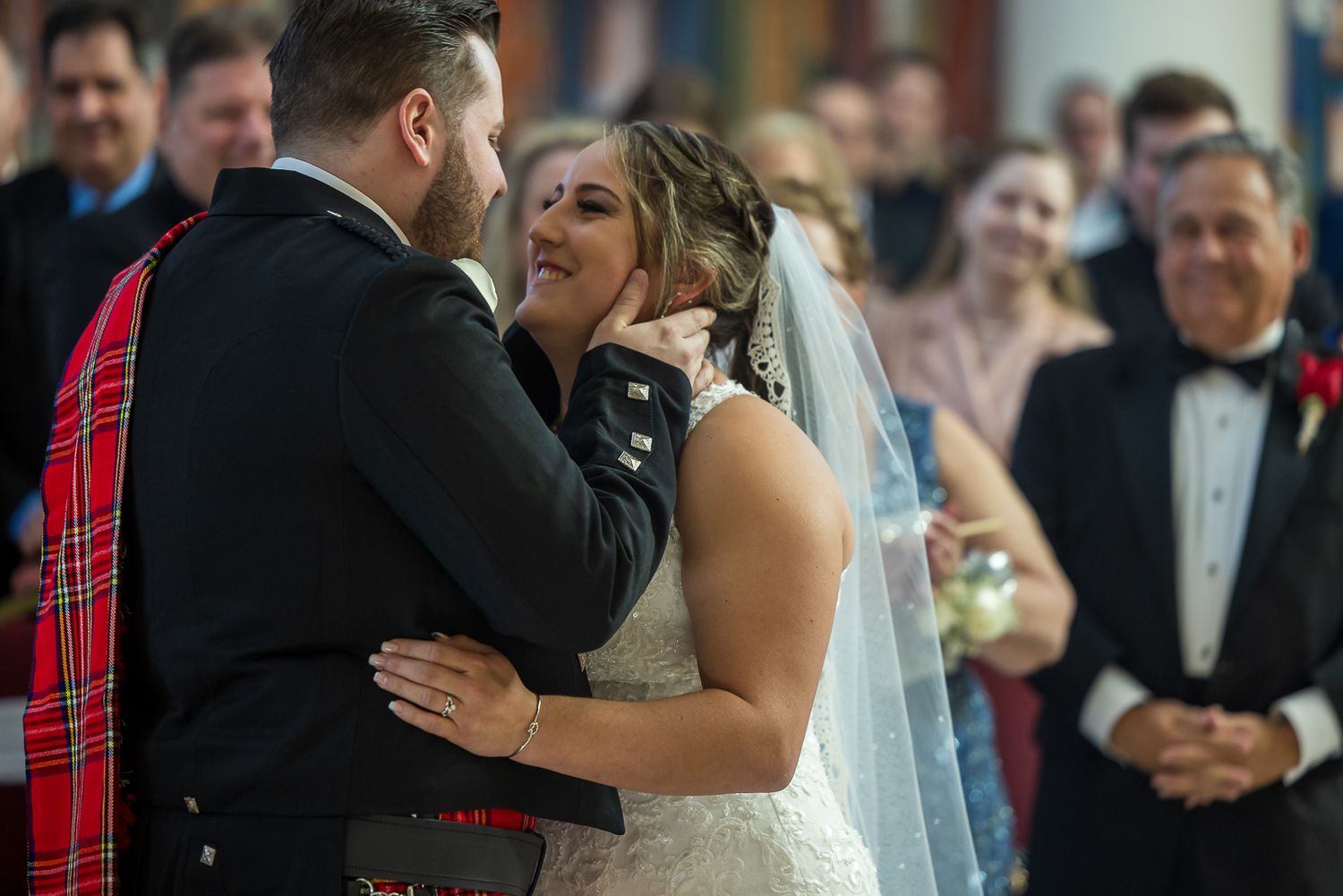 A couple shares a romantic dance moment at their wedding celebration surrounded by guests.