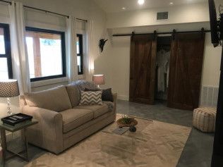 Modern basement living room features gray sectional sofa, wood accents, and recessed lighting for a cozy atmosphere.