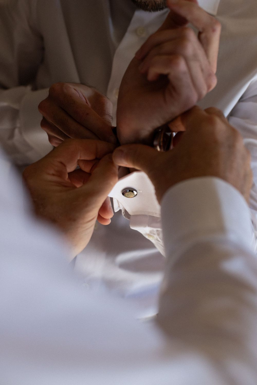 Hands working with a small sewing needle and white thread on light-colored fabric in a sequence of close-up shots.
