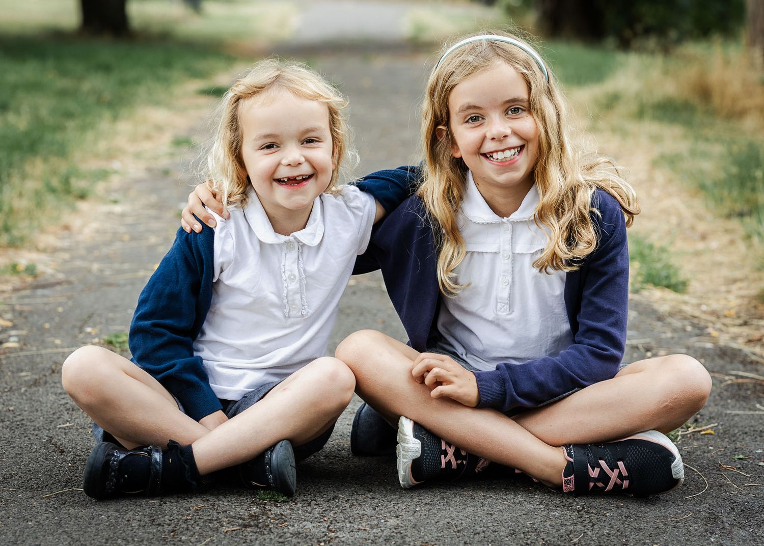 Two siblings look happy and smile to camera their relaxed outdoor school photography day in Bristol
