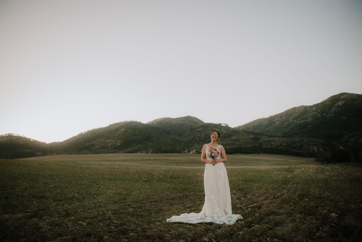 Portrait of a bride holding her bouquet while standing in a field in Caledon, capturing a natural and elegant outdoor wedding moment