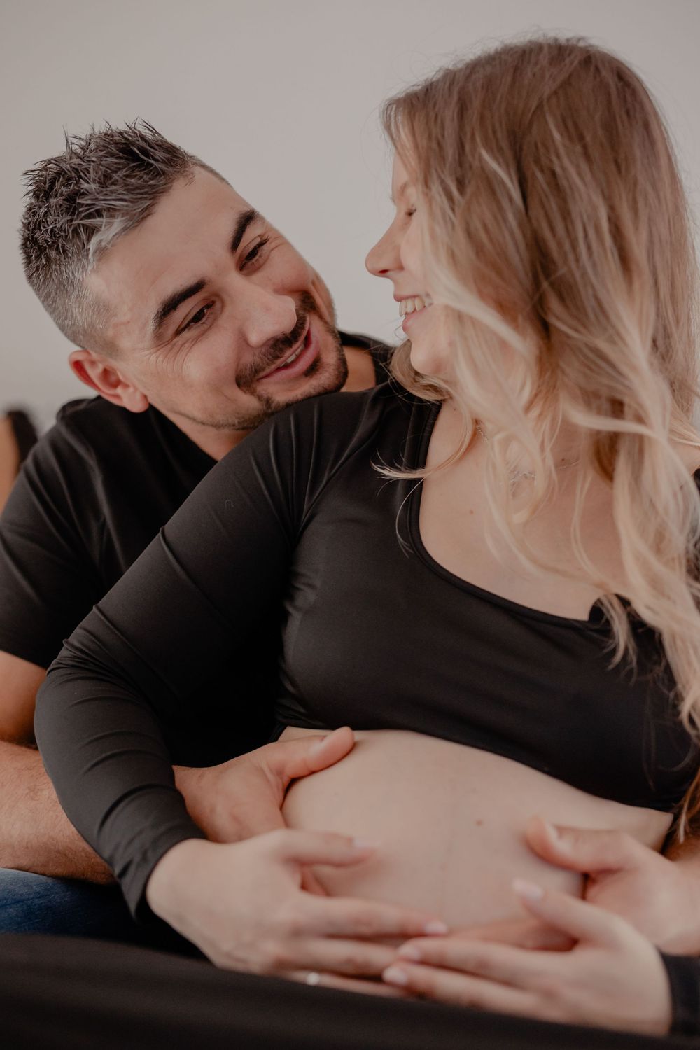 A romantic couple in black clothing embraces intimately in a series of tender poses.