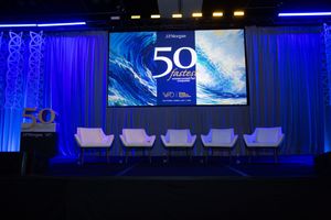 J.P. Morgan 50 Fastest Growing Companies award ceremony stage with blue lighting and white chairs.