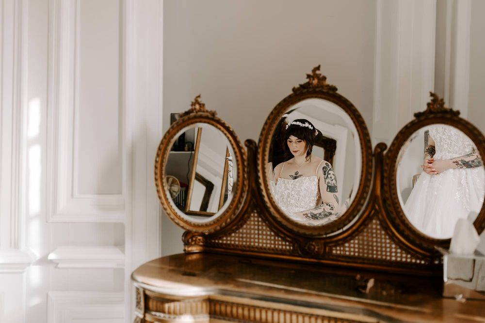Elegant vintage mirror frames with ornate gold details line a white wall in a classic interior setting.
