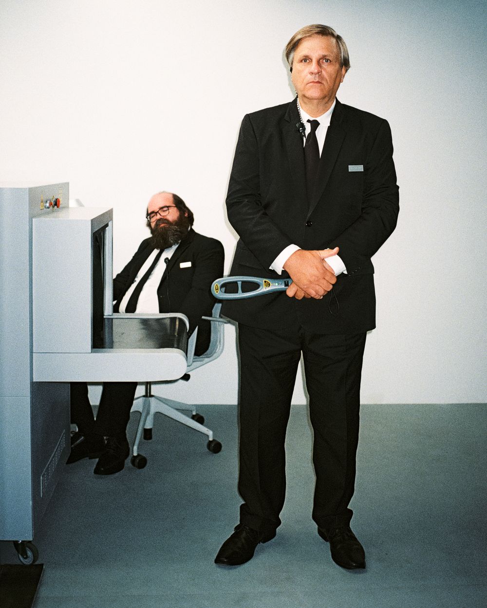 A series of black and white business portraits showing a person in a suit sitting and standing in an office setting.