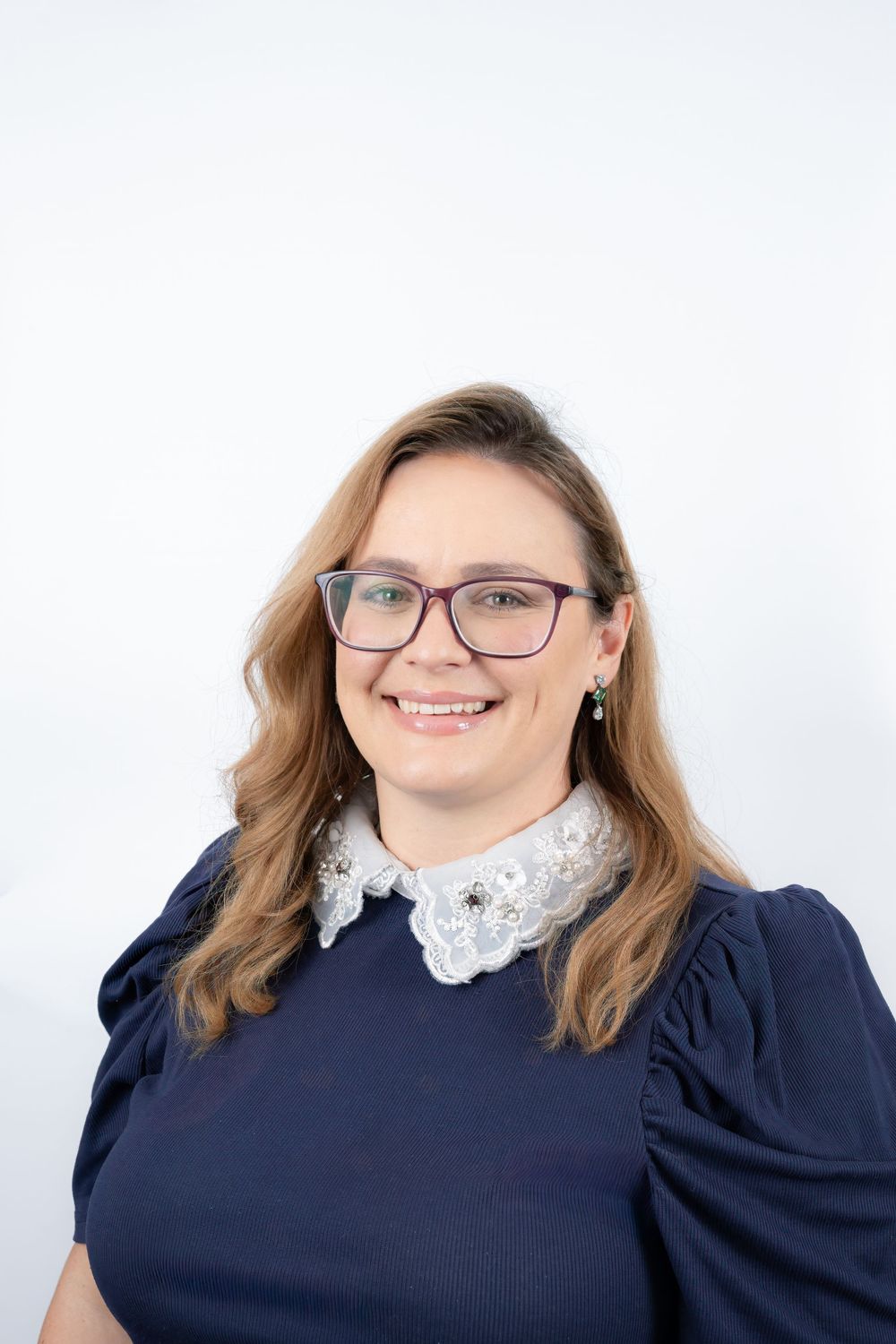 Professional headshot series showing a person in a navy sweater with white lace collar smiling against white background.
