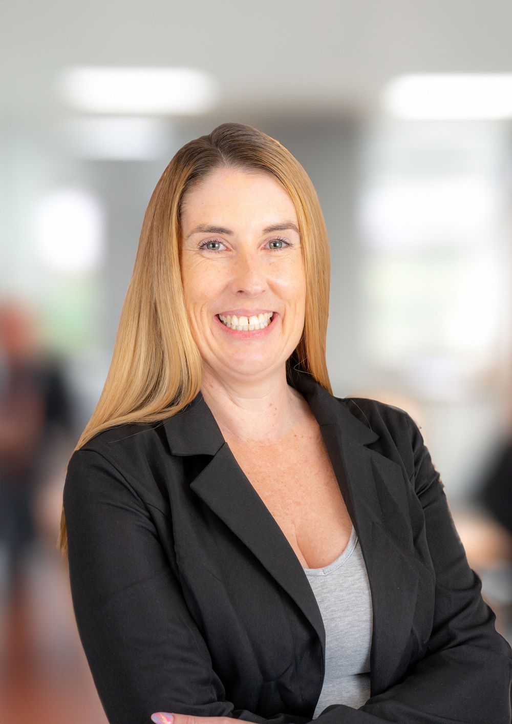 Professional in a black blazer and gray top shown in a series of headshots with varying expressions against a light background.