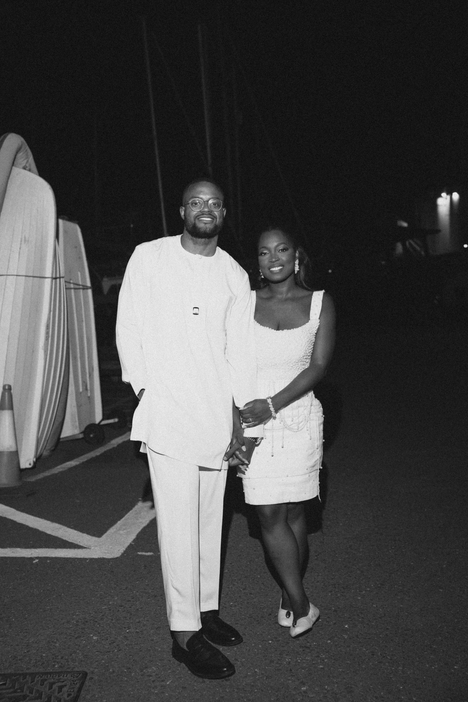 Black and white nighttime photos showing people in white clothing walking on a dark surface.