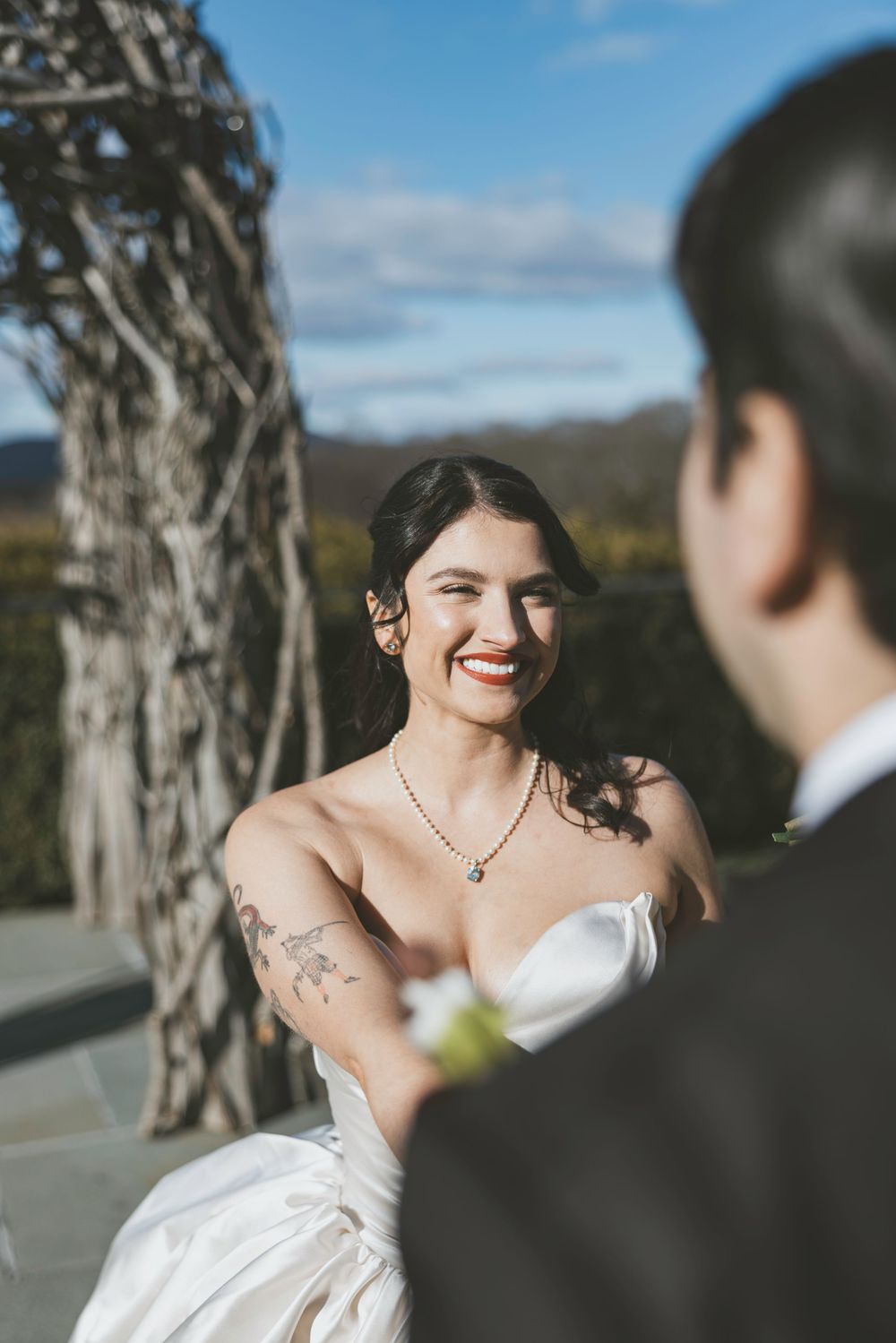 A joyful wedding moment captured outdoors with a scenic mountain backdrop and natural lighting.