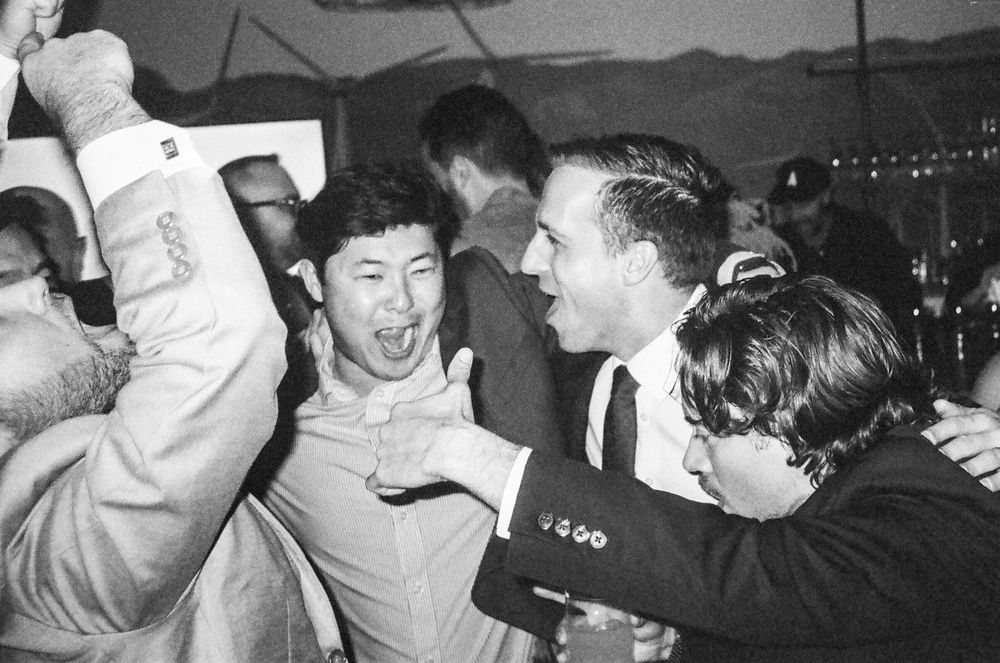 A montage of black and white photos showing people dancing and moshing at a punk rock concert.