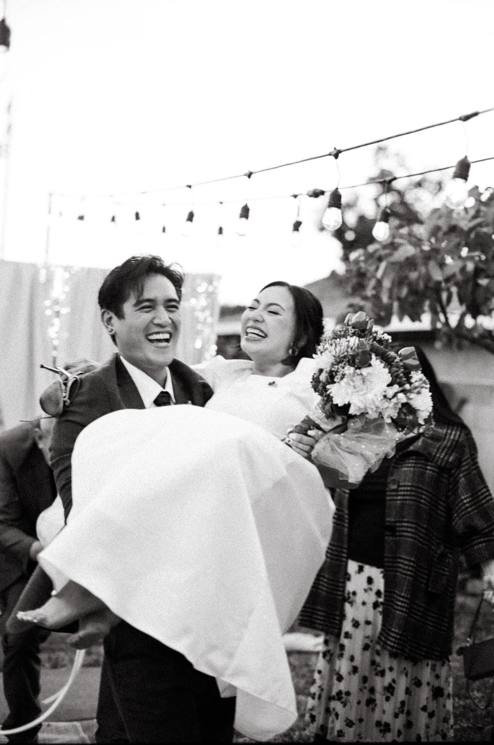 A couple shares joyful laughter in a series of black and white wedding photos showing candid moments.