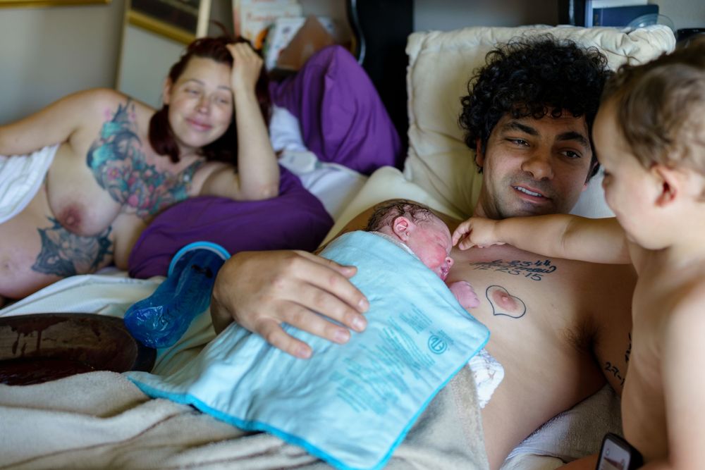 People relax together on a couch while applying an ice pack during a casual hangout at home.