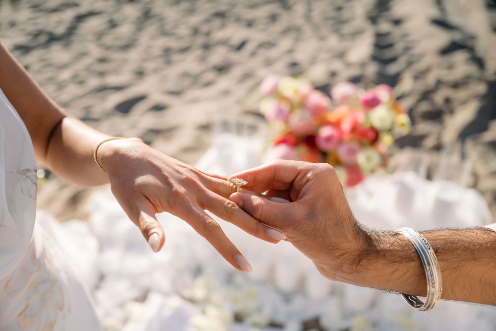 A close-up sequence of hands passing a diamond engagement ring during a romantic proposal moment.