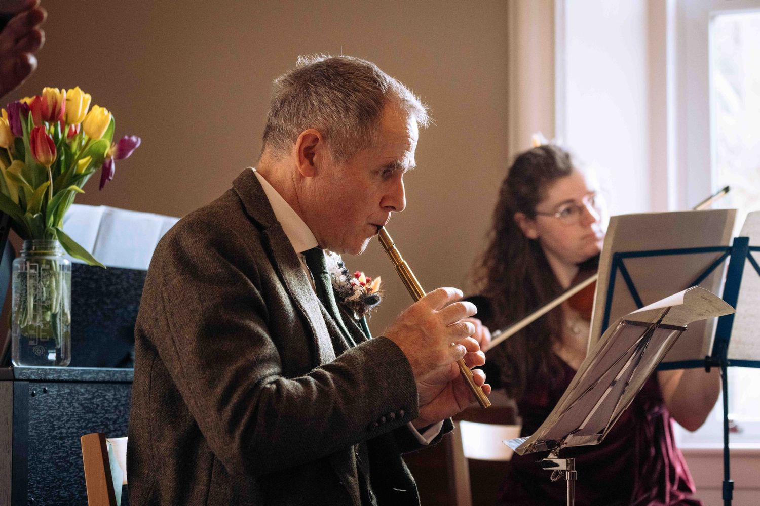 Musicians perform in a string quartet ensemble during a classical concert in an elegant room.