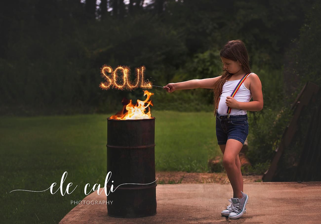 Outdoor photoshoot with illuminated 'SOUL' text and fire elements creating dramatic atmosphere.