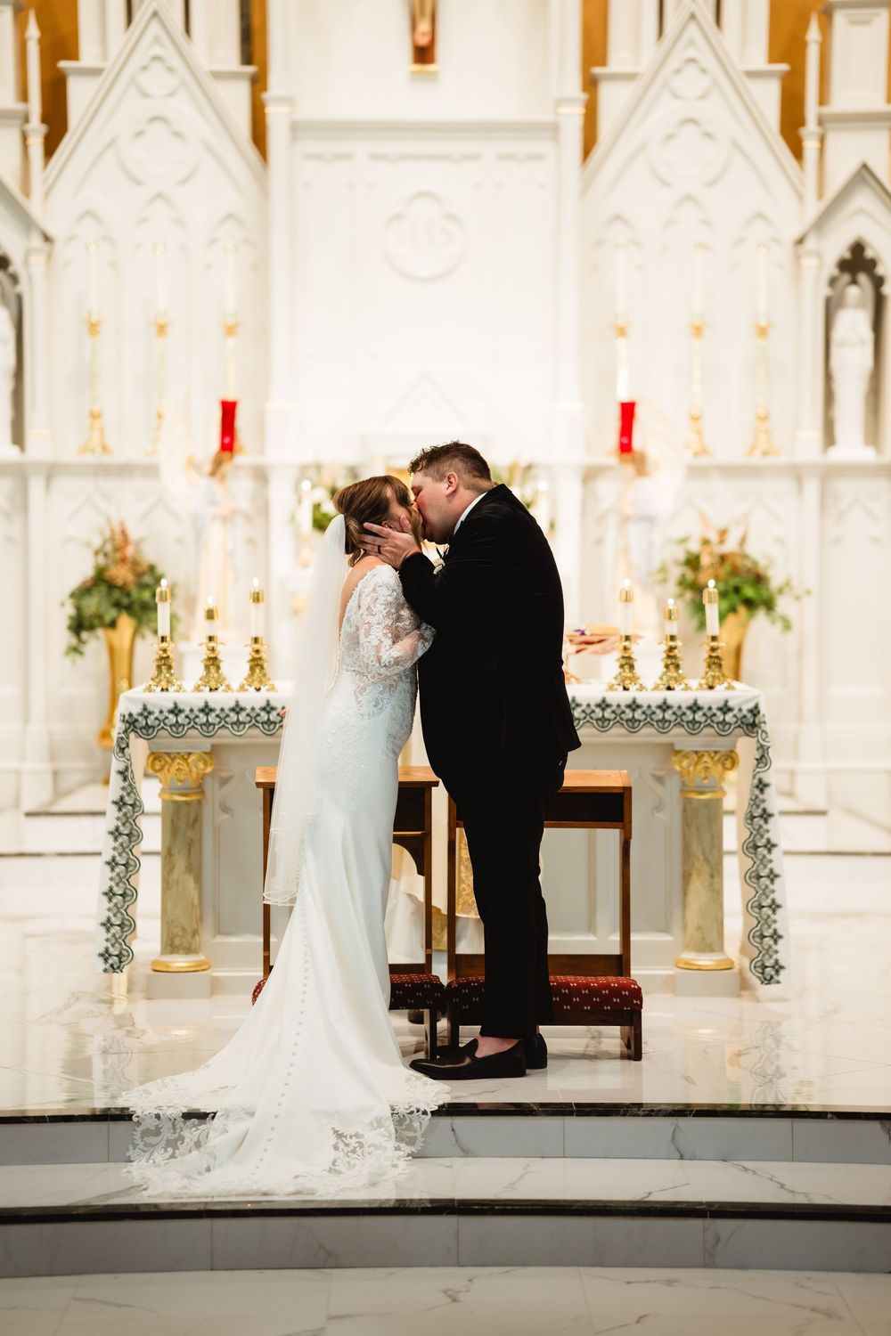 A romantic wedding ceremony takes place in an ornate white cathedral with gothic architecture and glowing candles.