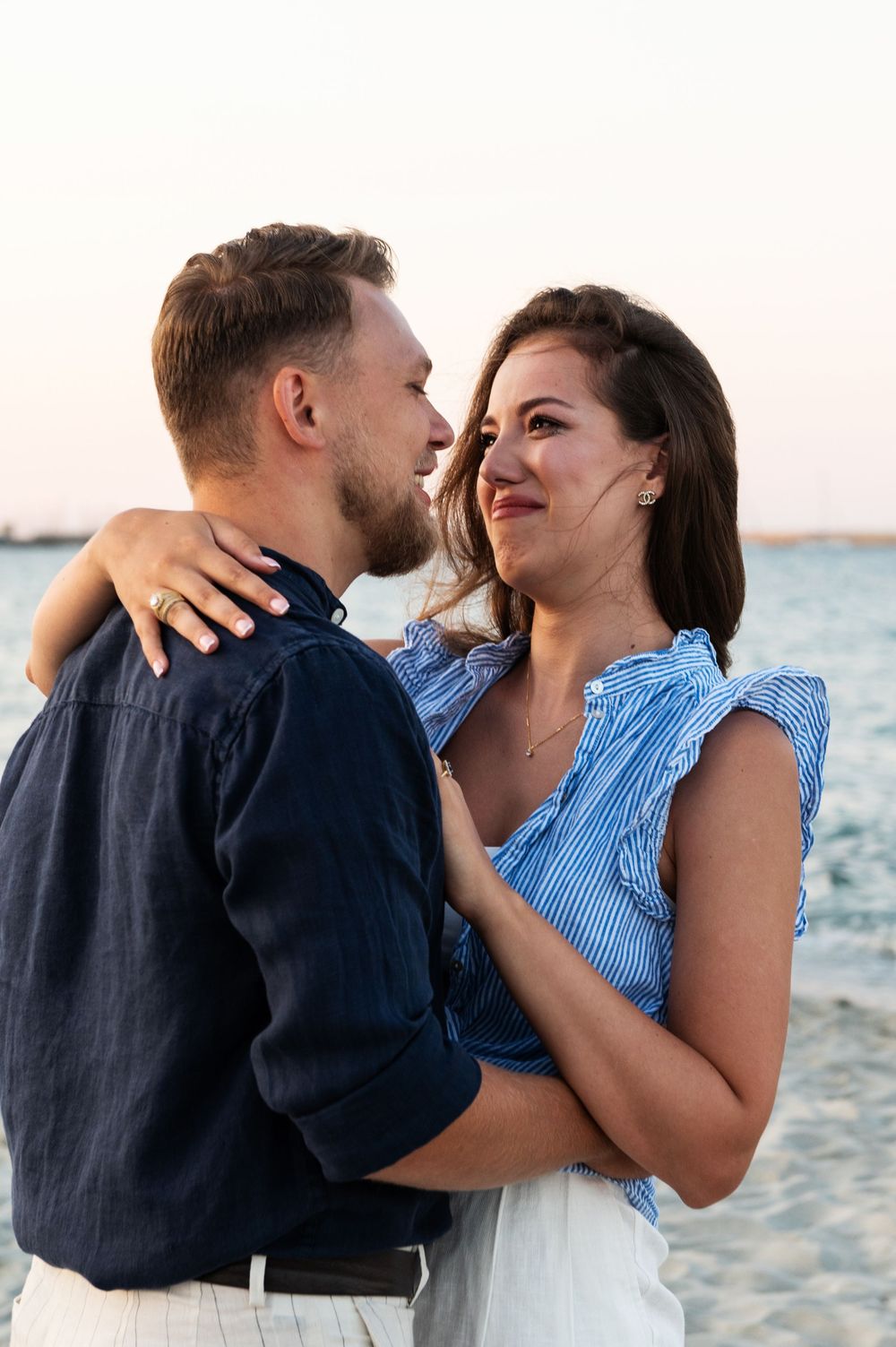 An emotional embrace shared between a couple on the beach during a special moment.