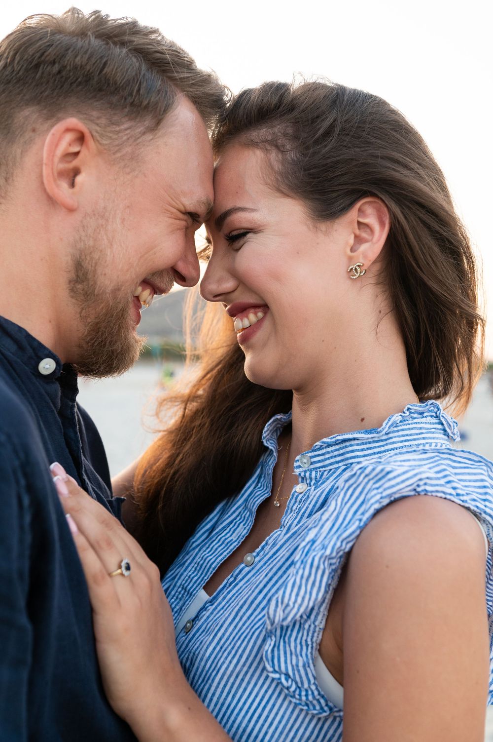 Sweet candid reactions during beachside engagement photography session.