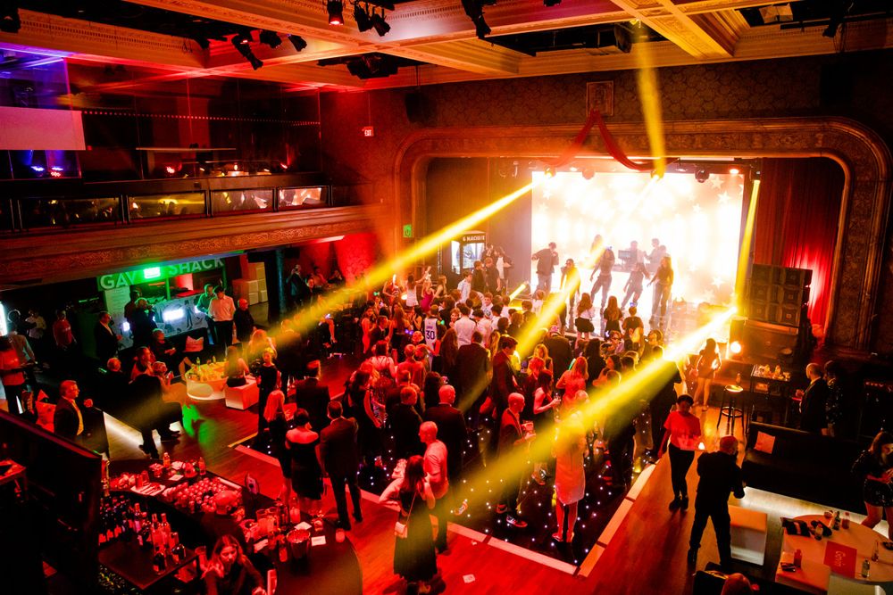 Energetic nightclub scene with golden spotlights streaming across the dance floor.