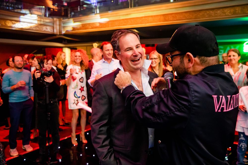Two attendees share an enthusiastic moment during a nightclub celebration.