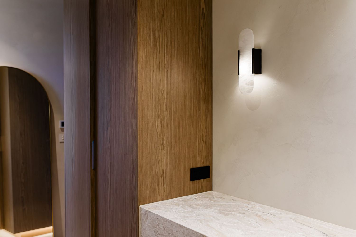 Modern minimalist hallway with wood paneled walls, recessed lighting, and white ceiling creates a sleek contemporary interior.