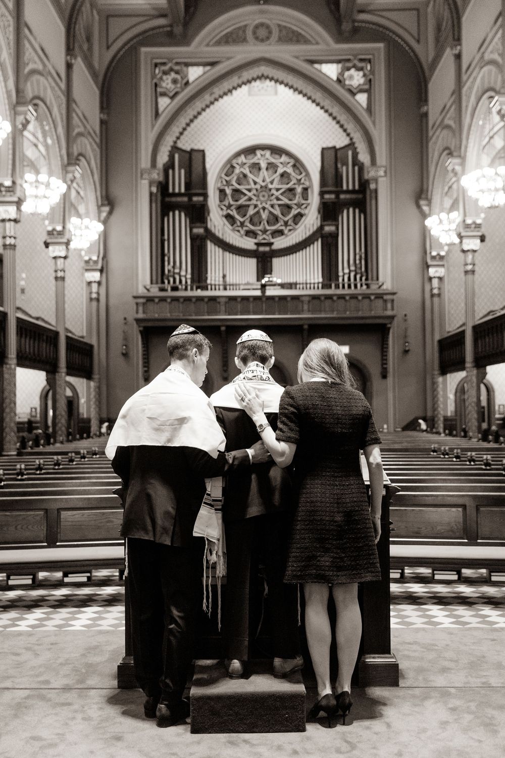A black and white photograph shows people gathered at a church altar with an ornate pipe organ in the background.