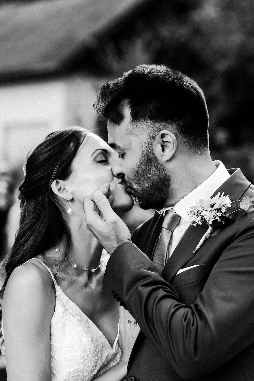 A romantic black and white photo sequence showing tender wedding kisses between a bride and groom.