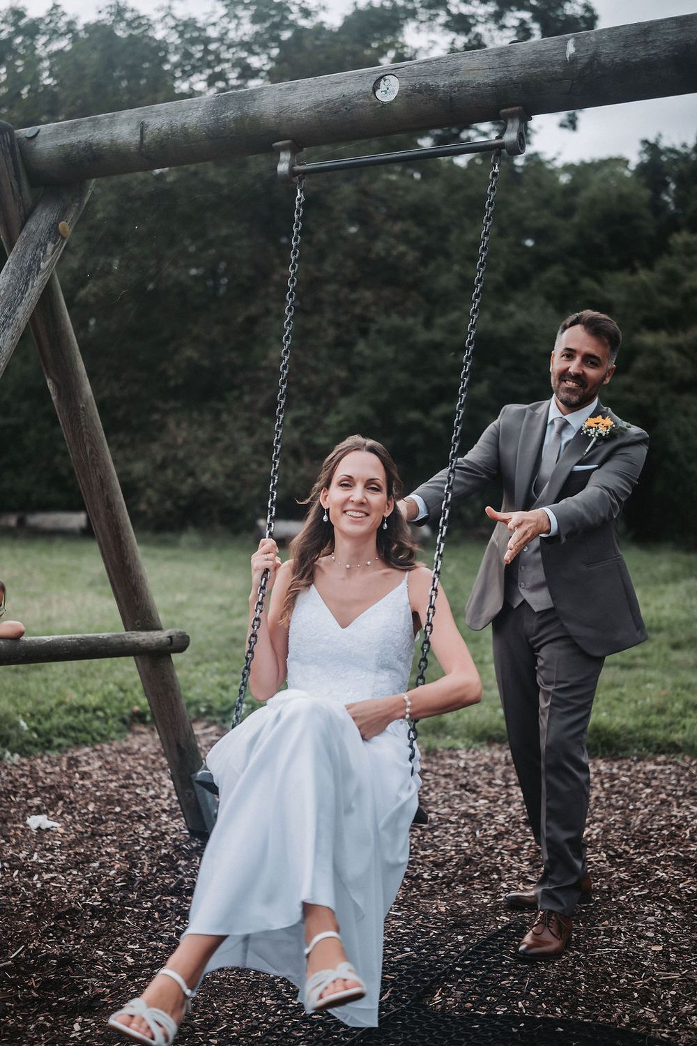 A series of playful wedding photos showing a couple having fun on a swing set in an outdoor setting.