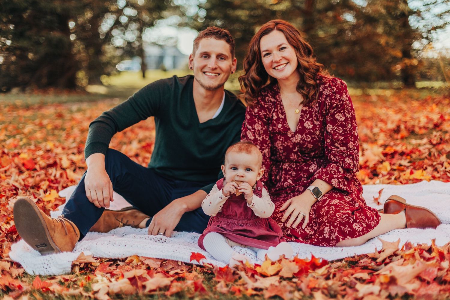 couple sitting in fall leaves