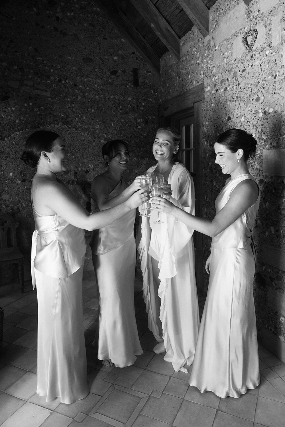 A sequence of black and white photos showing people in white dresses helping each other get dressed for a formal event.