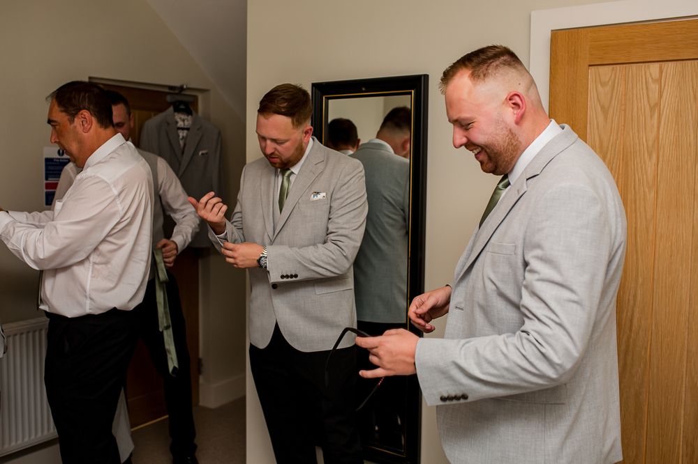 People in formal attire preparing for an event in an indoor setting.