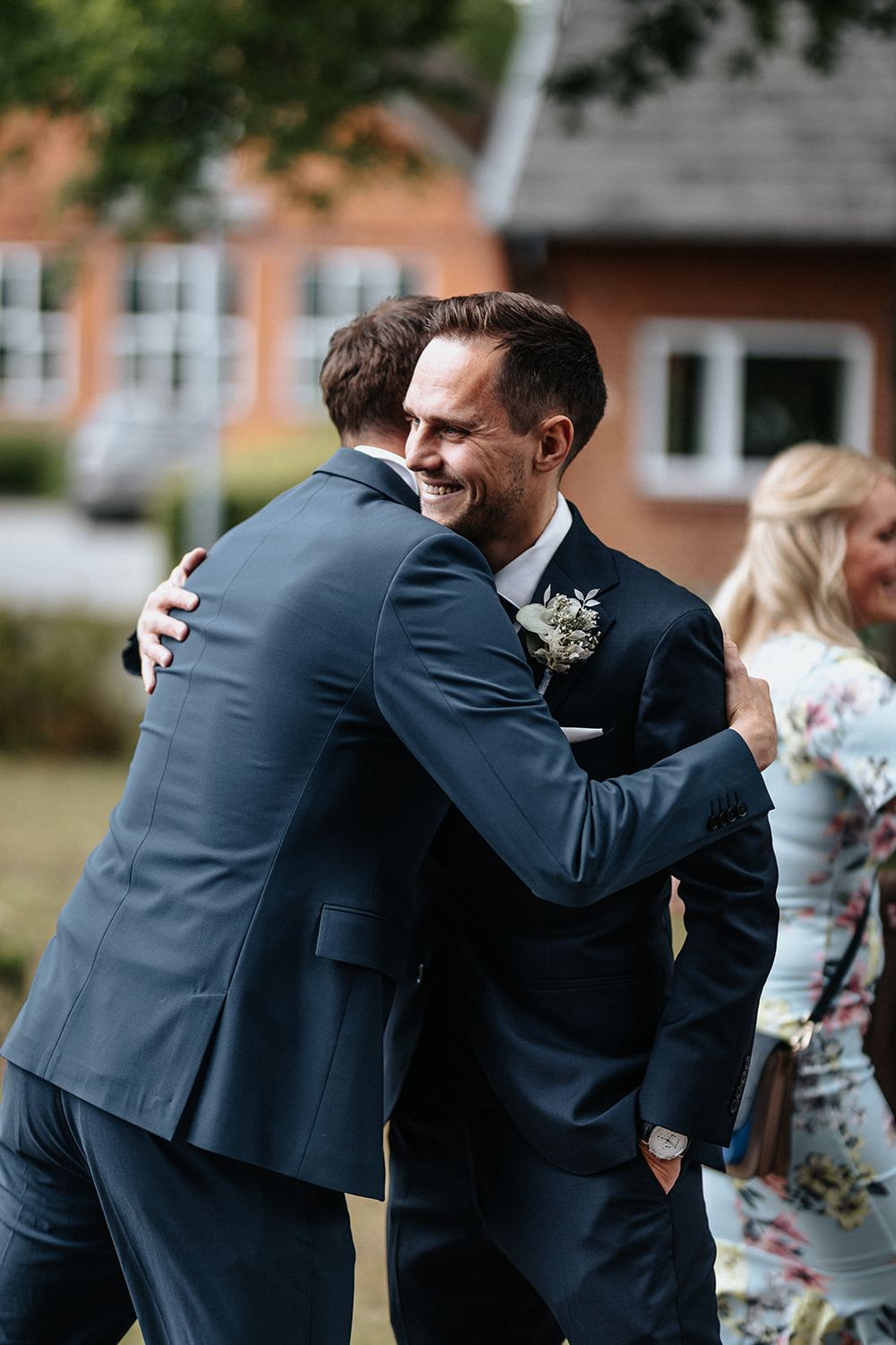 A sequence of emotional embraces between people in formal attire at an outdoor event.