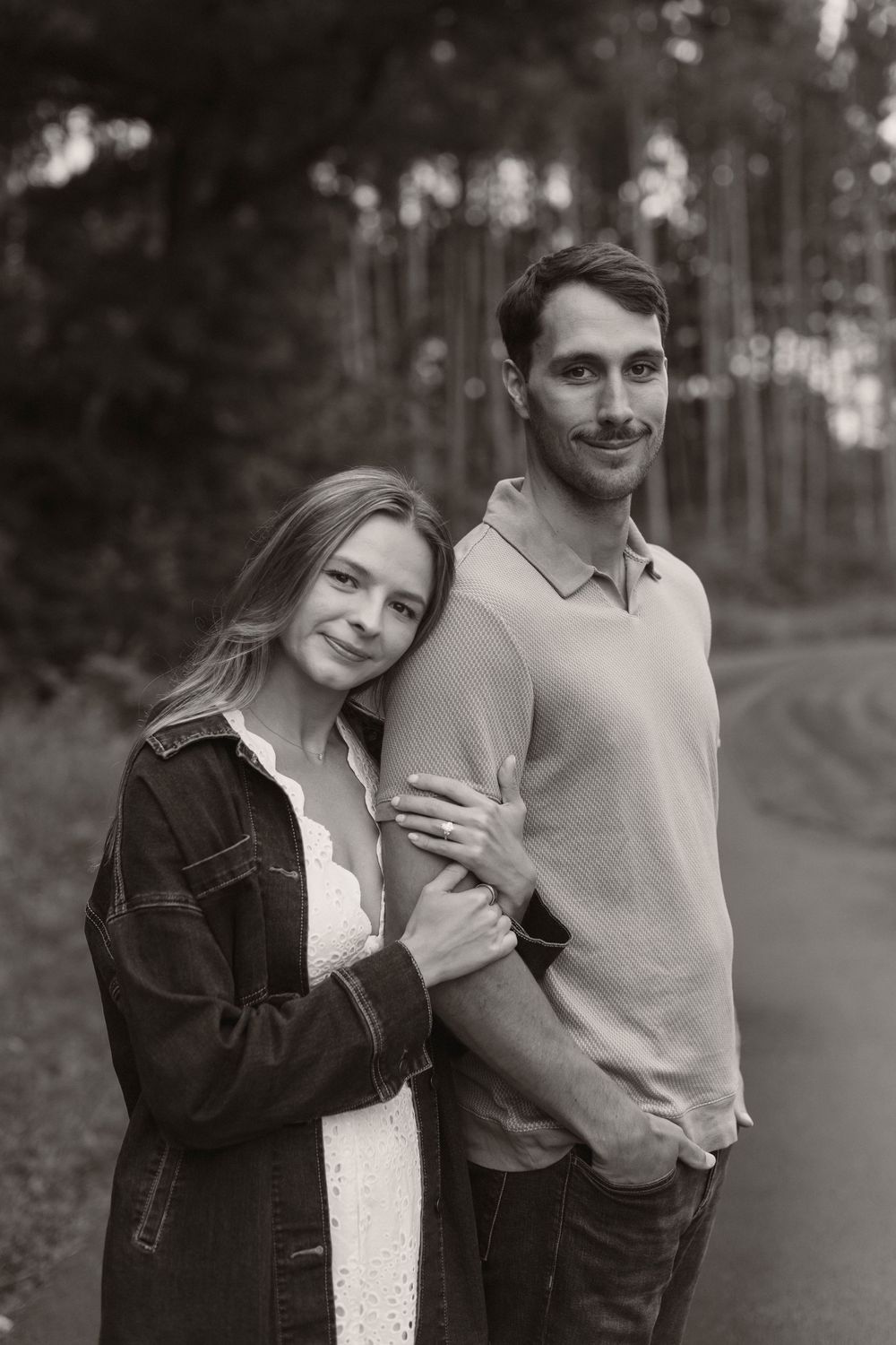 A romantic black and white portrait in a forest setting.