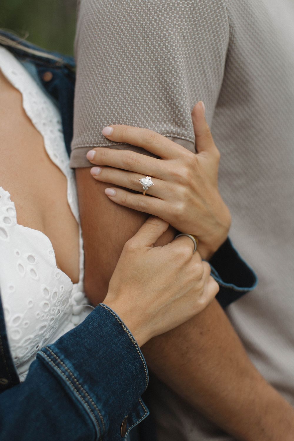 Close-up of hands showing an engagement ring in a romantic moment.