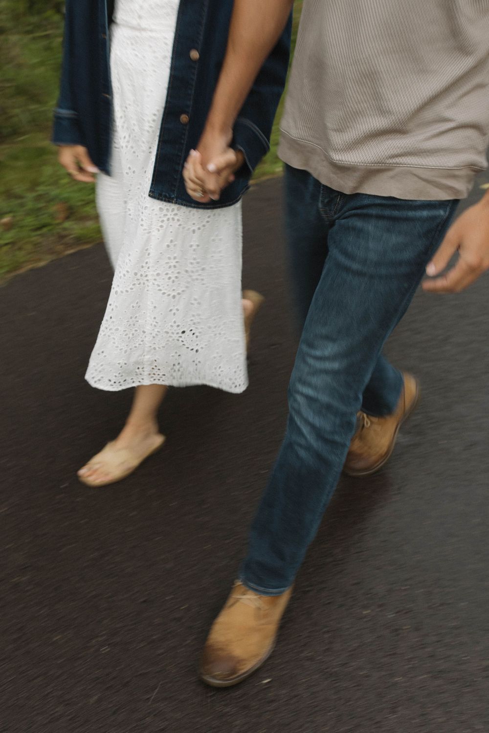 Couple's feet walking together, with white dress and jeans visible.