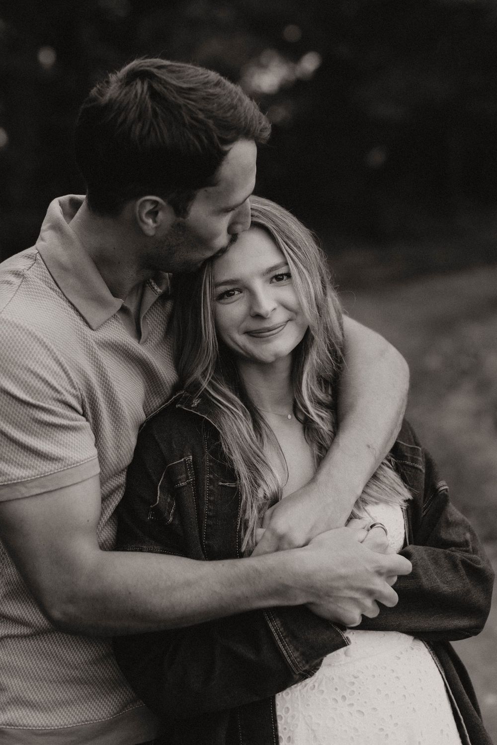 Black and white photo of couple sharing tender moments outdoors.