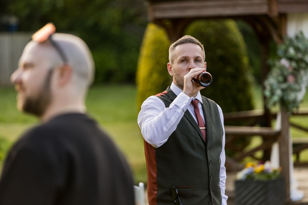 A performer sings into a microphone during an outdoor wedding event.