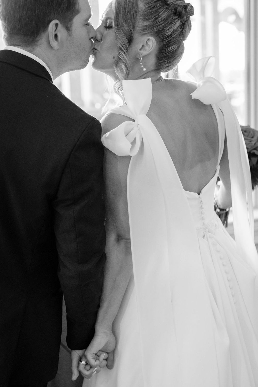 A romantic black and white wedding photo series showing tender kisses between a couple in formal attire.